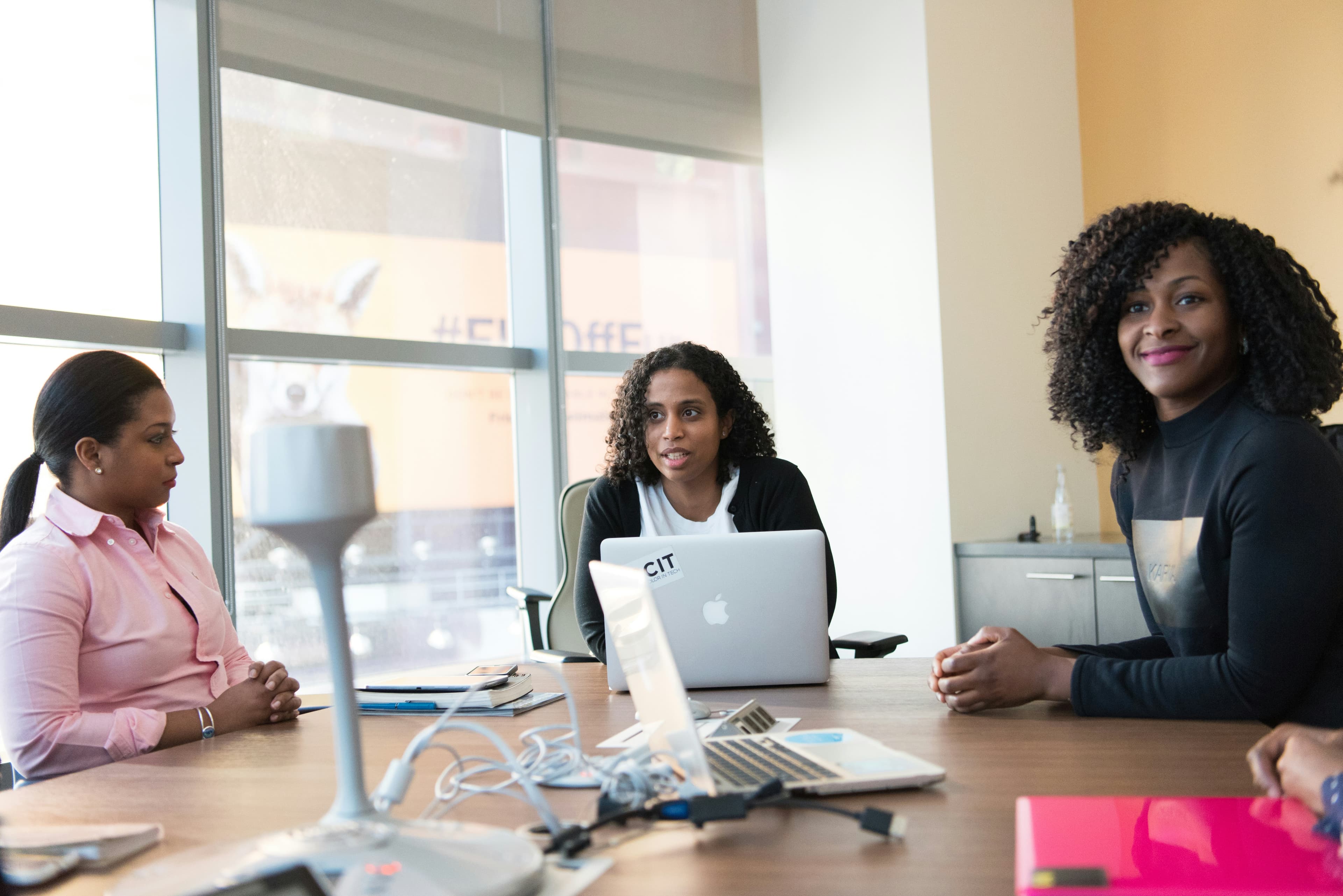 Black women technology professionals collaborating in a modern office